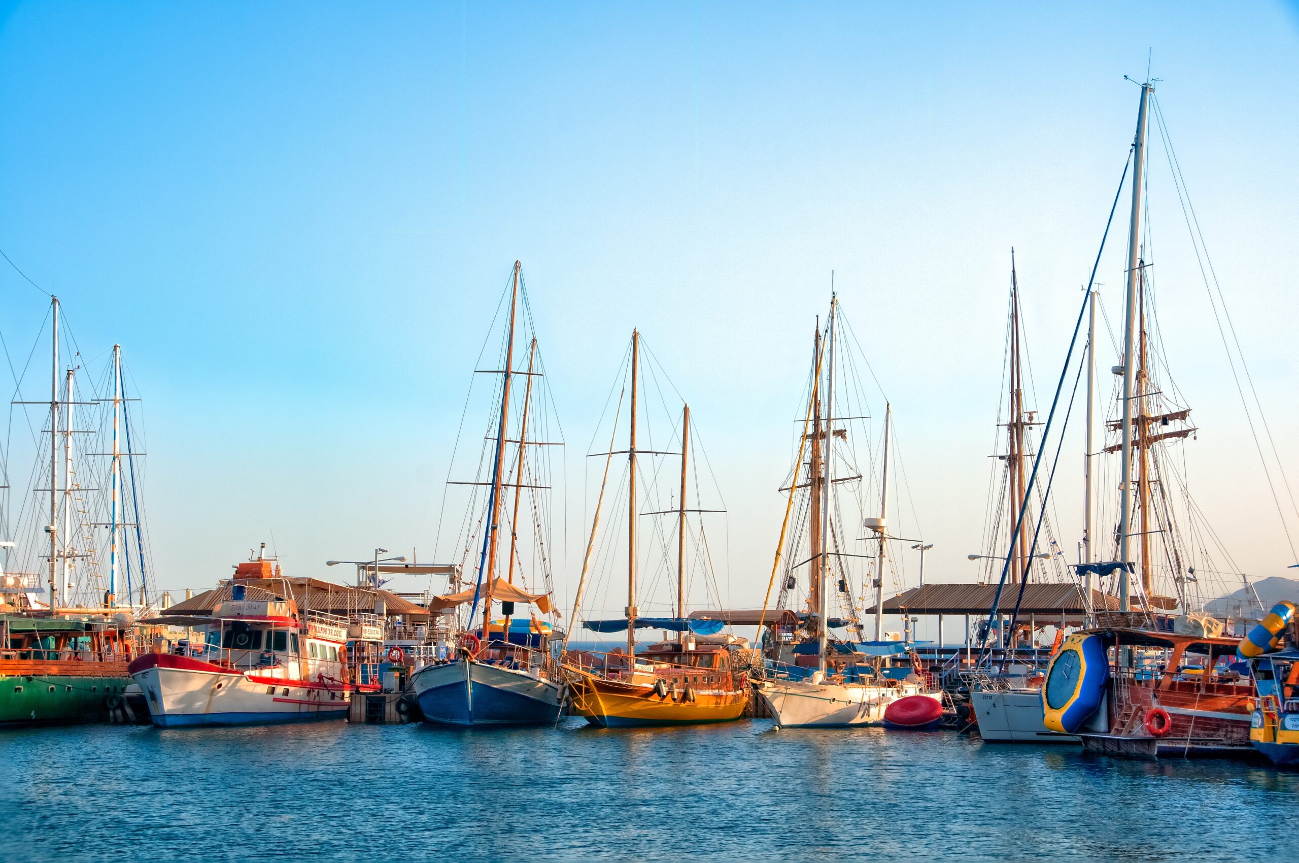 A high angle shot of beautiful boats parked in the pure water during the daytime